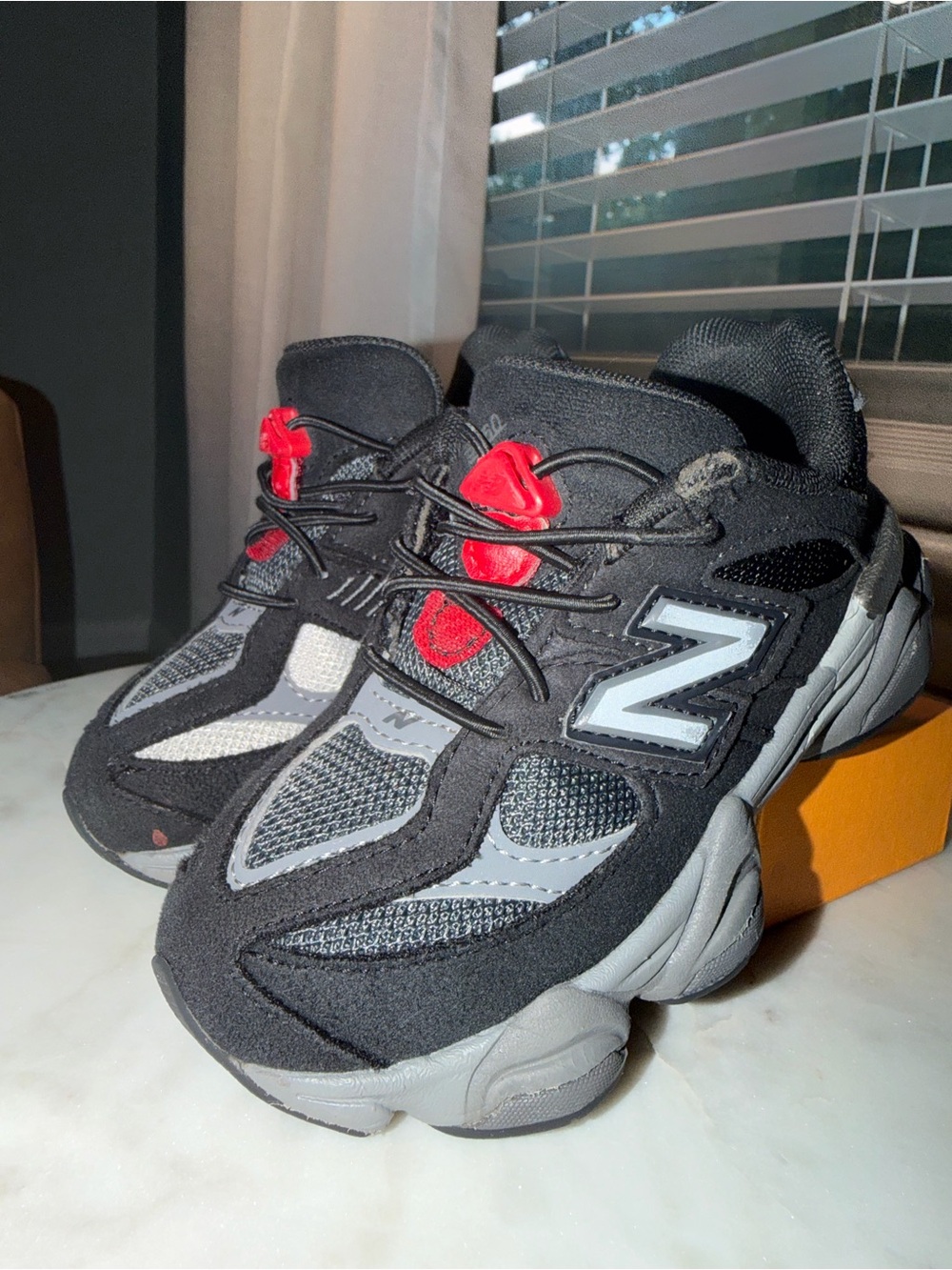 New Balance Kids Black and Gray Sneakers with Red Lace Accents